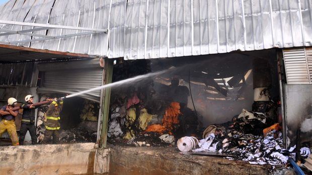Bomberos tratan de sofocar un incendio en una fábrica de papel en Villa Juana
