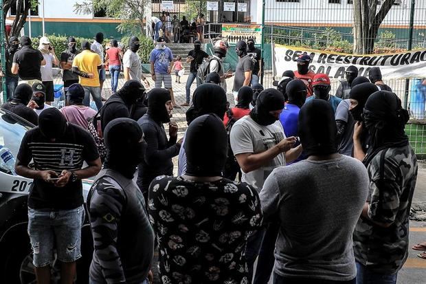 Personas encapuchadas y enmascaradas -supuestamente agentes de la policía- se concentran en el 18 Batallón de la Policía Militar durante el segundo día de huelga policial este jueves a la ciudad de Fortaleza, en el estado Ceará, Brasil. 
