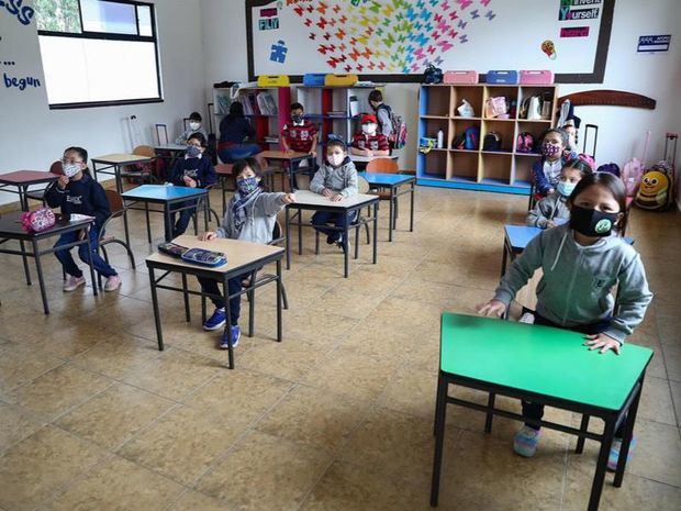 Varios estudiantes del EMDI School, ubicada a las afueras de la capital ecuatoriana, asisten a clases en escritorios con distanciamiento social hoy, durante el plan piloto para el retorno a clases en Quito, Ecuador.