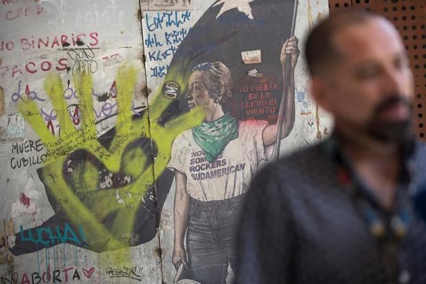Un mural realizado durante las protestas en Chile con la poetisa Gabriela Mistral se observa atrás del director del centro cultural Gabriela Mistral (GAM), Felipe Mella, mientras habla durante una entrevista el 10 de noviembre de 2020 en Santiago, Chile.