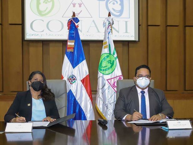 Presidenta Ejecutiva de CONANI y Director de Bienes Incautados firman documento.