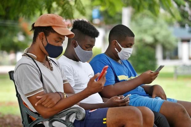 Jóvenes observan sus teléfonos, en una zona wifi, en La Habana, Cuba.
