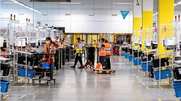 Varios trabajadores en el nuevo centro logístico de Amazon en Illescas que hoy ha sido inaugurado por la ministra de Industria, Comercio y Turismo, Reyes Maroto.