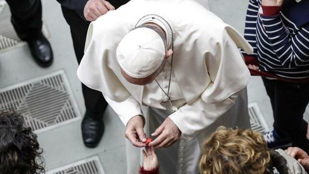 El papa Francisco saluda a una niña. 