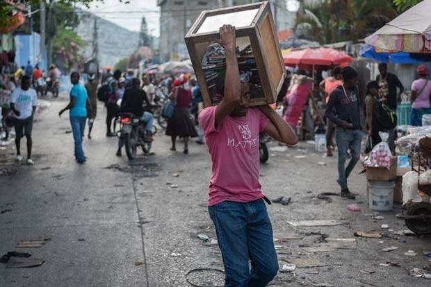 Un hombre transporta una caja hoy, en Puerto Príncipe (Haití). Una tímida reanudación de actividades se produjo este sábado en la zona metropolitana de la capital de Haití, luego de una semana de manifestaciones violentas para exigir la renuncia del primer ministro, Ariel Henry, y el rechazo al aumento en el precio de los combustibles.
