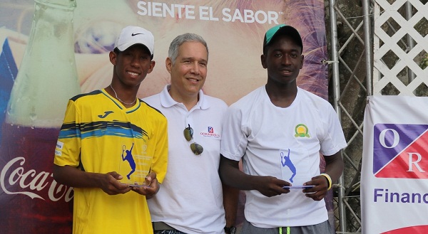 El señor Nelson Ochoa, galardona a los mejores en la categoría de 18 años masculinos del torneo nacional de tenis, José Arias y Maikel Vargas