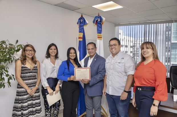 Suleyma Mejía recibe su certificado de las manos de Jorge Morales viceministro de MIPYMES; de izquierda a derecha Isabel Reynoso; Shaina Alonso; Cristian Hernández, director de servicios; y Melissa Rodríguez, encargada del depto. De Fomento a la competitividad.