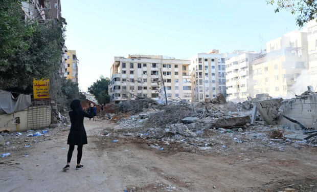 Una mujer se encuentra junto a edificios destruidos en el barrio de Haret Hreik, en los suburbios del sur de Beirut (Líbano).