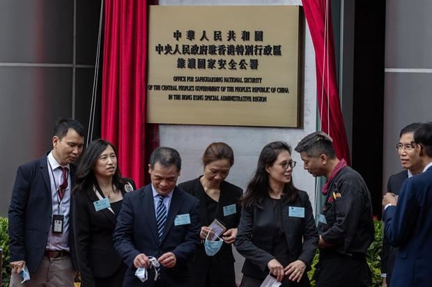 Los invitados pasan la señal de la Oficina de Protección de la Seguridad Nacional de Pekín en Causeway Bay, Hong Kong, China. 