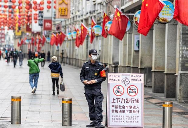 Un policía vigila el uso de mascarillas en una zona comercial de la ciudad de Guangzhou, en China. 