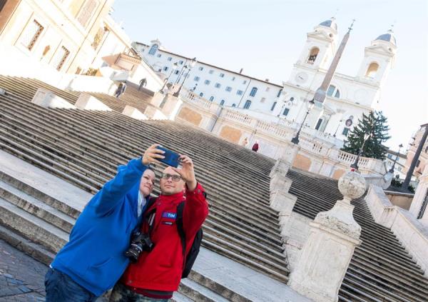 Una pareja se hace un selfi ante la escalinata de la Plaza de España en Roma. 
