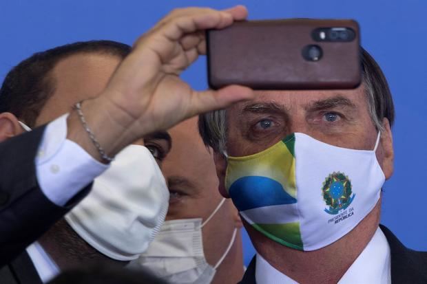 El presidente de Brasil, Jair Bolsonaro (d), fue registrado el pasado martes al tomarse una fotografía, durante un evento oficial en Brasilia, Brasil.