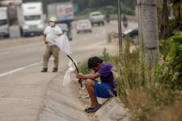 Un niño ondea una bandera blanca en la carretera pidiendo ayuda por hambre debido a la crisis economica provocada por el coronavirus, el 29 de abril de 2020, en El Tejar, Guatemala.