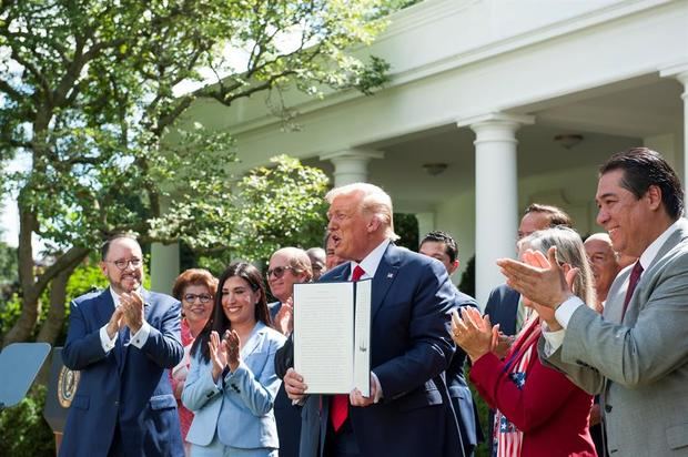 El presidente de EE.UU., Donald J. Trump (c), sostiene la orden ejecutiva con la que crea la Comisión de Asesores para la Prosperidad de los Hispanos, este 9 de julio de 2020, en la Casa Blanca, Washington (EE.UU.)