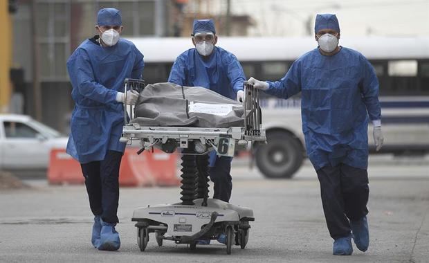 Empleados de la salud conducen este martes una camilla con el cuerpo de una persona fallecida por la Covid-19, al centro forense del Hospital General en la fronteriza Ciudad Juárez, en el estado de Chihuahua, México.