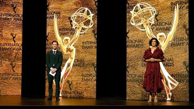 Fotografía cedida hoy, por los Premios Emmy Internacional donde aparecen los actores británicos Tom Payne y Indira Varma mientras participan en la ceremonia de entrega de los premios de la 48 edición.