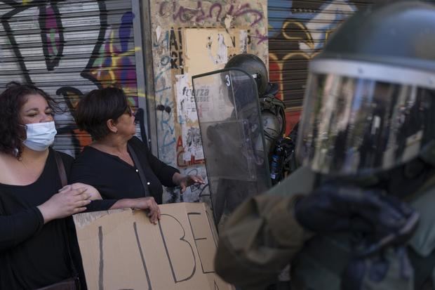 Personas se enfrentan a la policía, hoy durante la conmemoración del estallido social, en Valparaiso, Chile.
