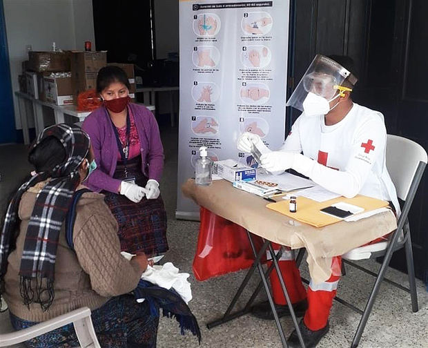 Fotografía cedida por la Cruz Roja Internacional que muestra a uno de sus funcionarios mientras realiza labores de atención médica en medio de la pandemia, en Guatemala.