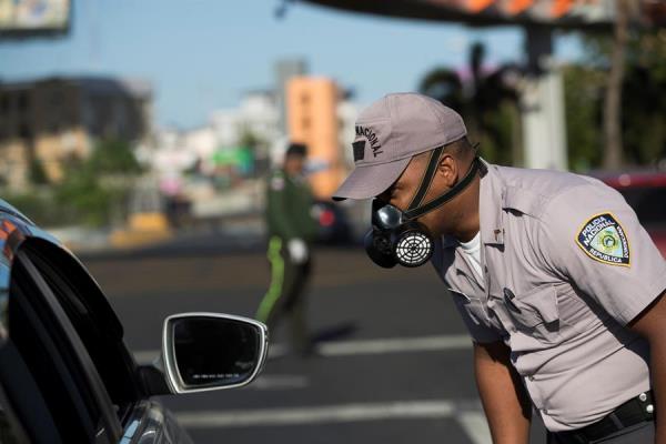 Un agente policial detiene a un automovilista durante el toque de queda este martes, en Santo Domingo (República Dominicana). 