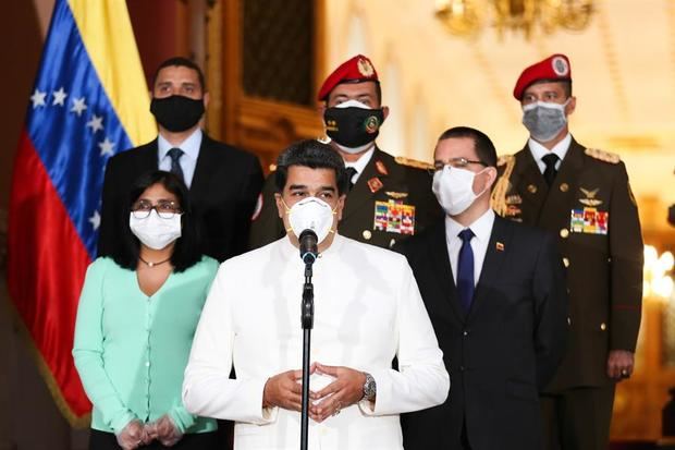 Fotografía cedida por el Palacio Presidencial de Miraflores que muestra al presidente de Venezuela, Nicolás Maduro (c), usando una mascarilla durante una declaración este lunes desde el Palacio de Miraflores en Caracas, Venezuela. 
