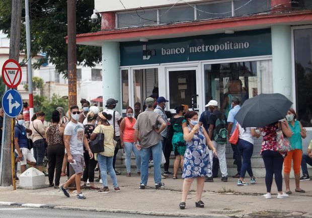 Varias personas esperan su turno para entrar a un banco hoy, en La Habana, Cuba.