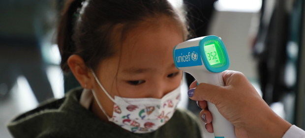 Toman la temperatura a una niña pequeña en Mongolia con un termómetro proporcionado por UNICEF para prevenir los contagios de Covid -19.